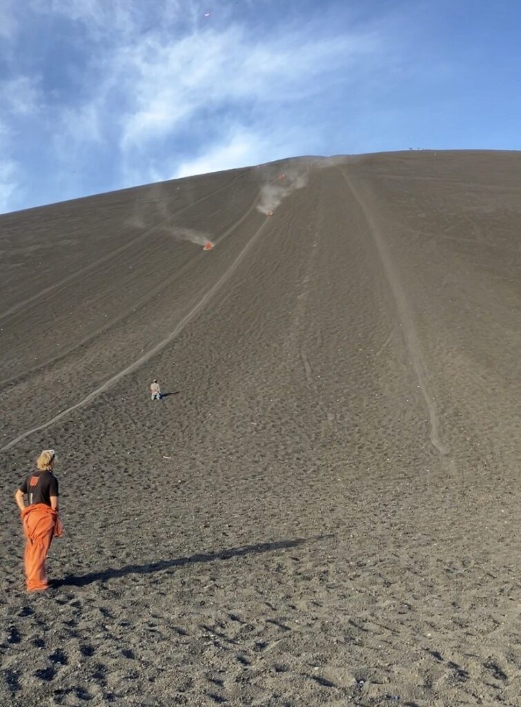 People sliding down the smooth black slopes of Cerro Negro in Nicaragua