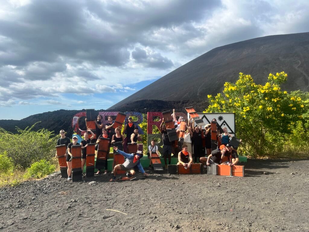 Group tour standing in front of a Cerro Negro sign outside of the volcano Cerro Negro in Nicaragua