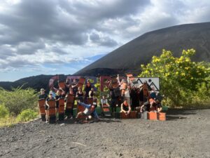 Group tour standing in front of a Cerro Negro sign outside of the volcano Cerro Negro in Nicaragua