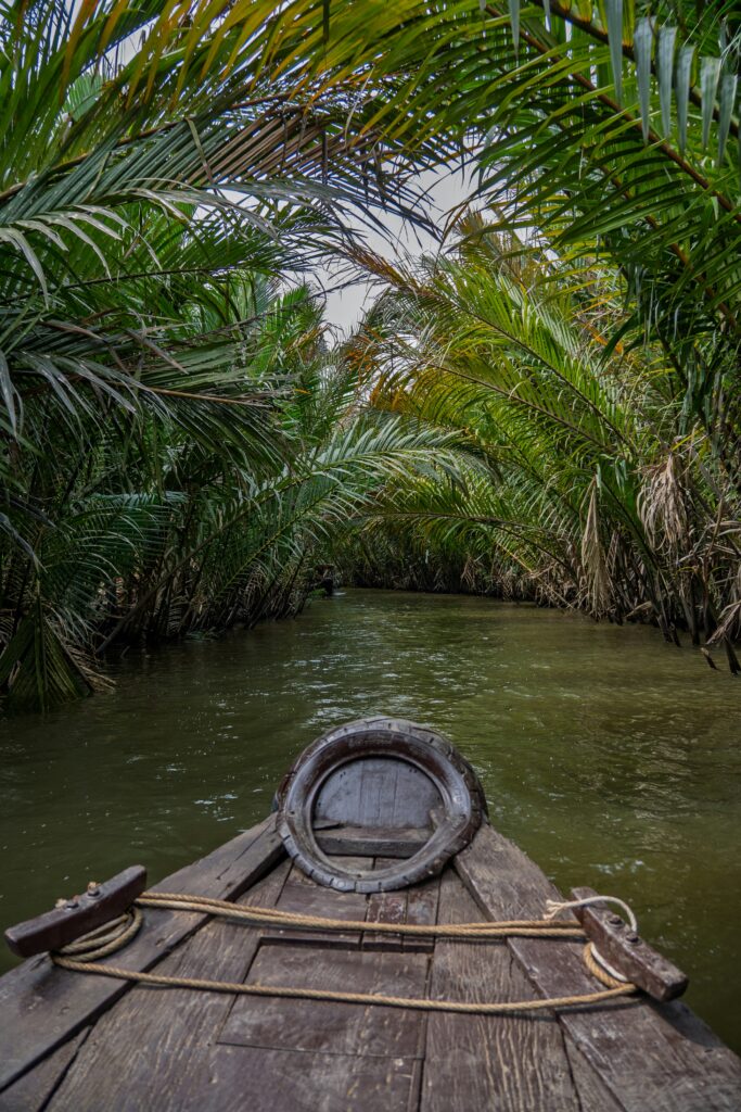 A conoe going down a narrow inlet of the Mekong Delta in Vietnam