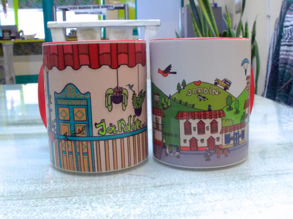 Two colorfully painted coffee mogs with a theme of Jardin, Antioquia Colombia