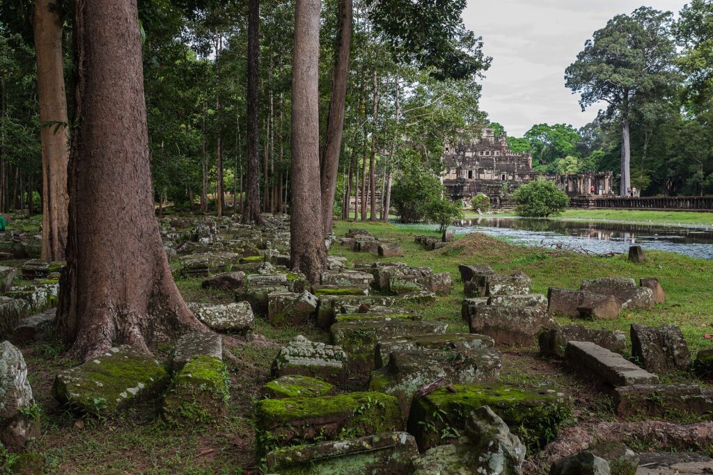Baphuon temple ruins surrounded by trees and greenery in Angkor Archaeological Park