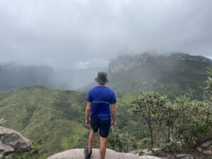 Me with my back turned, looking at cloud covered mountains