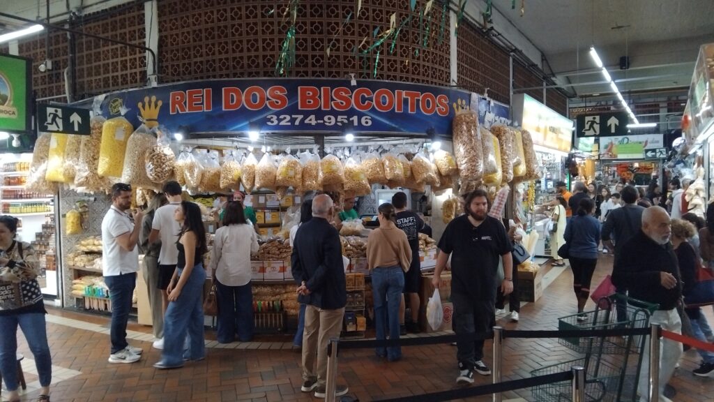 Several patrons standing in front of a cookie vendor at Mercado Central de Belo Horizonte in Brazil