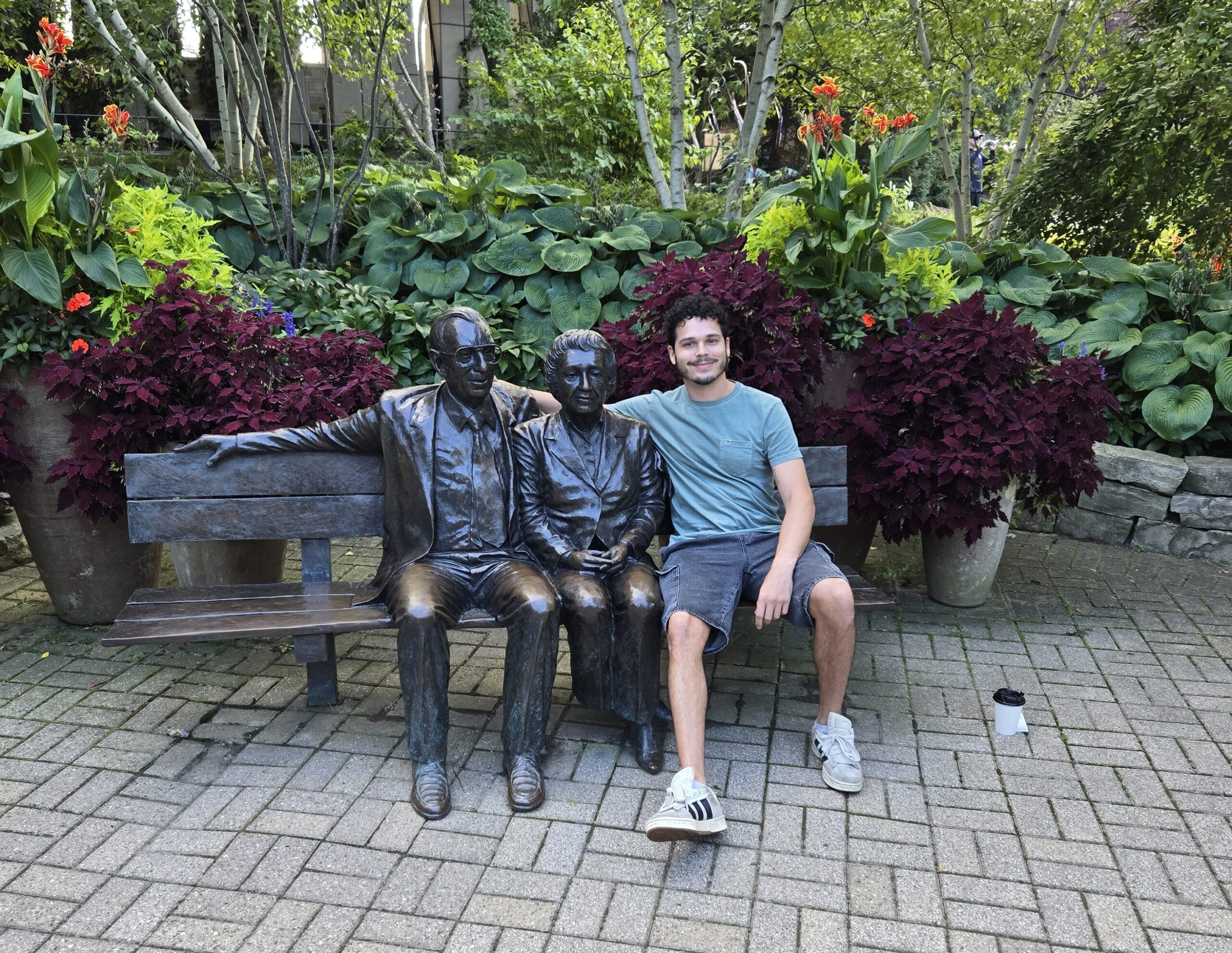 Me sitting on a bench, next to 2 statues of Frederik Meijer and his wife at Meijer Gardens & Sculpture Park