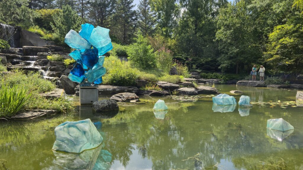 Pieces of abstract glass art by Dale Chiuly in an outdoor pond at Meijer Gardens & Sculpture Park
