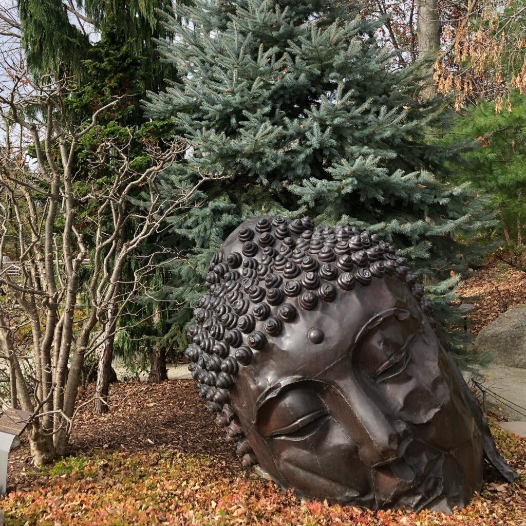 A Bronze sculpture of a head in Meijer Gardens & Sculpure Park in Autumn