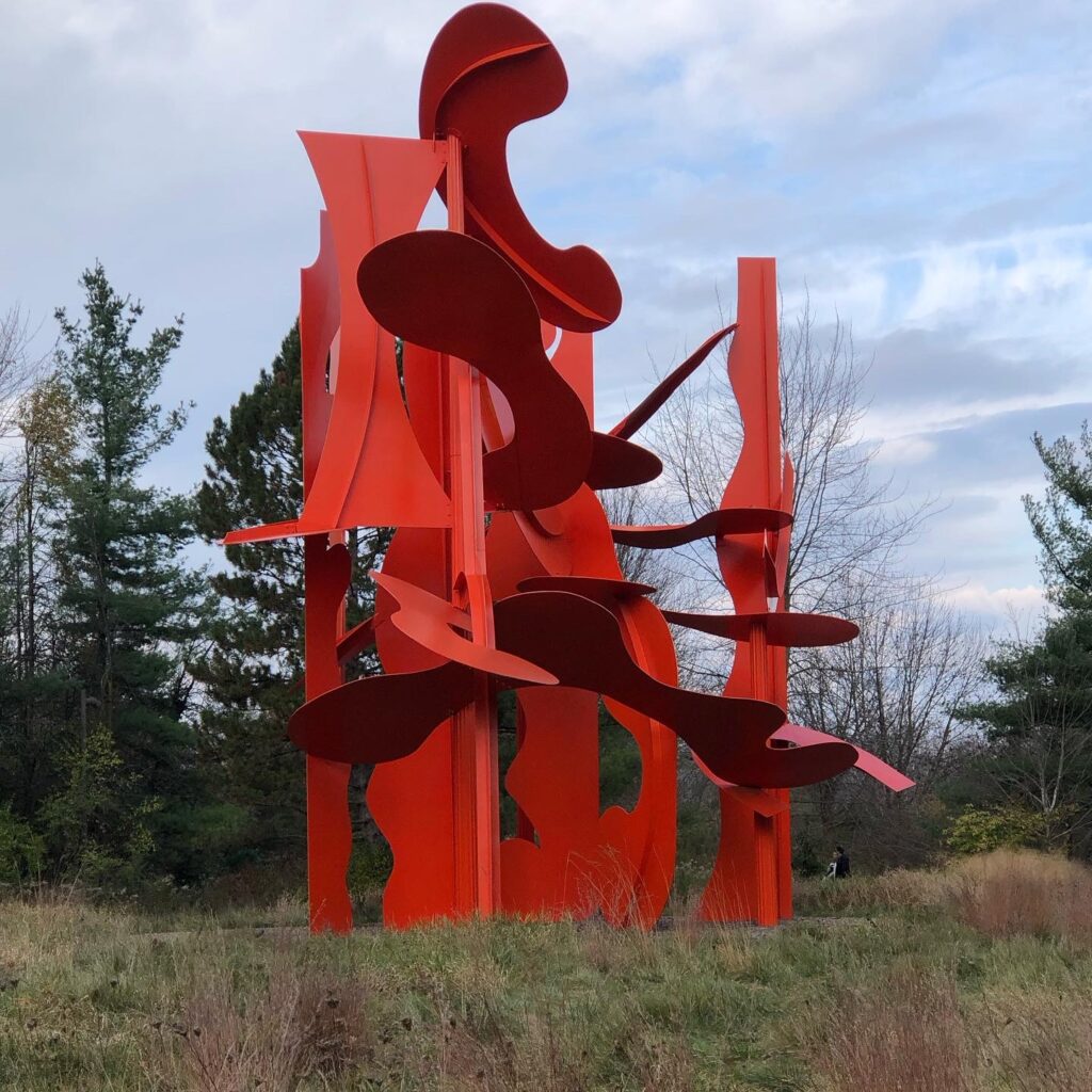 A huge red abstract metal art instillation outside at Meijer Gardens & Sculpture Park