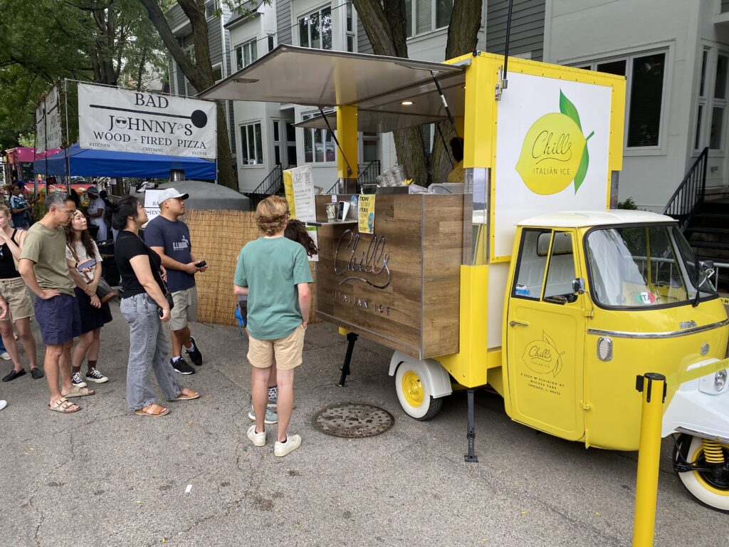 People standing in front of a food truck at a festival in Chicago