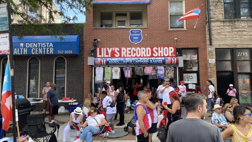 A group of residents in front of a record ship that sells Puerto Rican souvenirs
